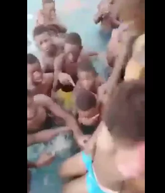 Boys fondle and grope helpless young girl in a crowded pool (Watch Video)